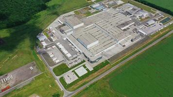 Industrial territory on green field. Roofs of modern manufacturing complex among nature. Industrial scene area. Aerial view. video