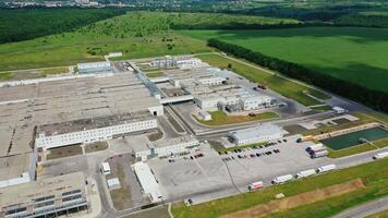 Exterior of modern manufacturing in nature. Large industrial complex with car parking among the environment in summer. Motion top down. video