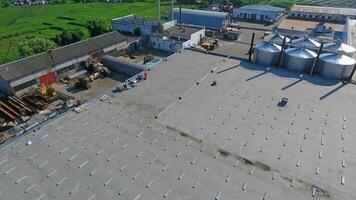 Construction on a rooftop. Building the solar farm on flat roof. Builders on construction site of future alternative power plant on the top of building. Aerial view. video