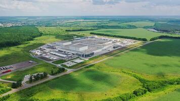 Industry surrounded by green nature. View from above on modern manufacture on field in a bright summer day. Aerial view. video