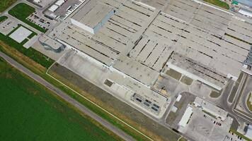 Industrial complex. Roofs of manufacture buildings on green field. Car parking for trucks on the territory of factory. Top view. video