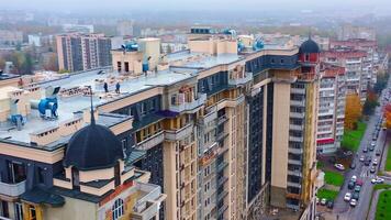 Construction site in the city. Modern architecture is building by workers. High-rise building under construction. Camera moves in a round way. Aerial view. video