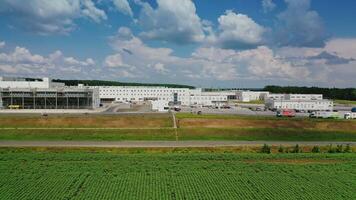 Modern complex under beautiful sky. Industrial plant with trucks on the territory. Factory in nature. Aerial view. Camera moves to the right. video
