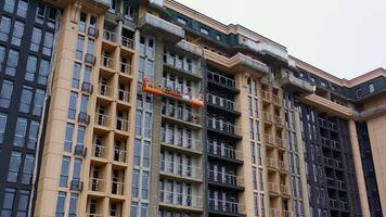 Building of new tower architecture. Modern multi storey building under construction. Front view of a high-rise building. Workers build the tall house. video