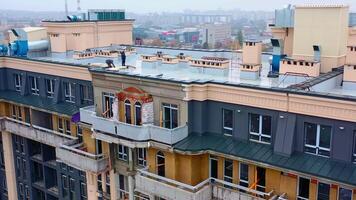Building of a new tower house. Workers on the roof of multistorey building during the construction on the cityscape. Aerial view. video