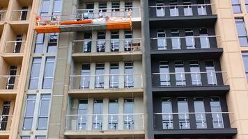 Front view of a new modern building. Construction of a high-rise apartment. Workers doing the outdoor view of a multistorey building. video