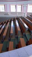 Lecture hall in the university. Panoramic view of educational center indoors. Large auditorium with empty desks during pandemic. Vertical video