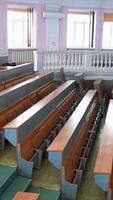 New auditorium for conference meeting. Empty lecture hall in the university during quarantine. Spacious classroom with rows of long desks for students to study. Vertical video