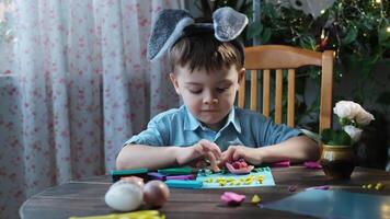 Easter DIY crafts. Small child creating Easter greeting card using coloured paper end plasticine. video