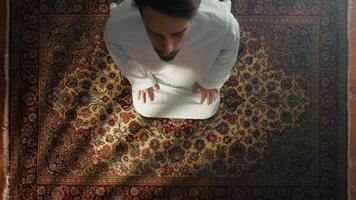 Man Kneeling On Carpet Prays During Ramadan video