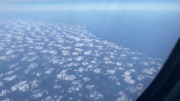 Aerial view of clouds beautifully spread over the vast ocean seen from an airplane window video