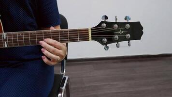 Close up of a musician practicing fingerstyle guitar in a music school, showcasing the precise hand positioning and technique required for this intricate playing style video