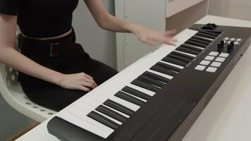 Female musician immersed in creativity while playing a midi controller in her home studio, skillfully composing electronic music using a digital audio workstation video