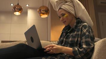 Funny young European woman with towel on her head and patches celebrating winning or getting ecommerce shopping offer on computer laptop. video