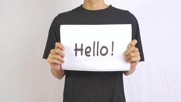 a footage of a man holding a piece of paper with hello written on it video