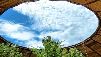 Wooden round building with an open circle in ceiling sky view. video