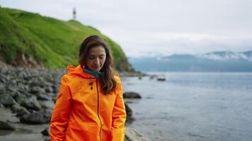 Young Adult Woman Tourist In Raincoat Walking On Shore And Exploring Touristic Location In Kamchatka video