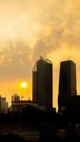Sunset silhouette vertical time lapse of tower cranes working on site project in a city. video