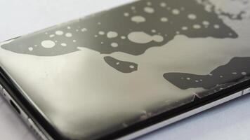 Water droplets dynamic movement on smartphone screen surface in closeup highresolution. video