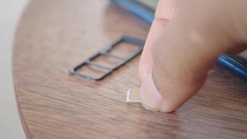 Detailed CloseUp of a SIM Card and Its Tray on a Wooden Table Surface video