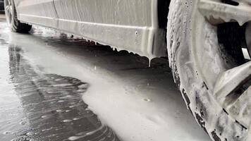 Close up of a white car being cleaned with foam, emphasizing vehicle maintenance and cleanliness video