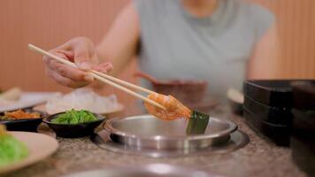 Savoring the Flavor, Close-up shot of a hand using chopsticks to pick up a piece of food from a hot pot, capturing the essence of a satisfying and delicious meal. video