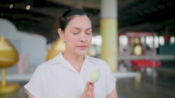 Peaceful Meditation. A woman in a serene setting, holding a lotus flower, finds tranquility in a moment of peaceful meditation, reflecting a sense of inner peace and connection to spirituality. video