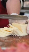 a processo do fatiamento queijo dentro uma bem equipado cozinha configuração video