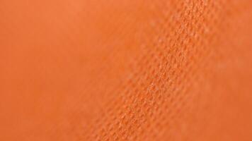 Macro close-up of vibrant orange fabric with rich texture and woven details photo