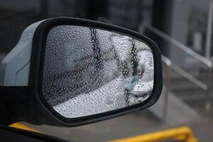 Detail of car mirror wet by raindrops photo