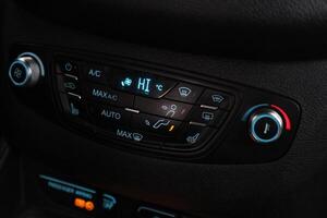 Car black interior dashboard with temperature, adjustment of the blower, air conditioner and other buttons photo