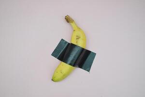 A Single Banana Secured With Dark Tape photo