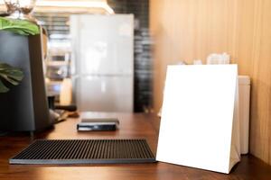Empty blackboard on desk in coffee shop bar blurred background. Template for text and ad. photo