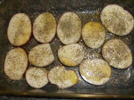 A pan filled with sliced potatoes and herbs photo