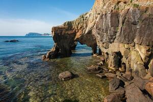 Drone view of an elephant-like natural stone arch on the seashore photo