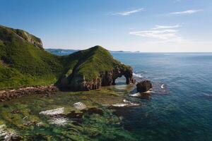 Drone view of an elephant-like natural stone arch on the seashore photo