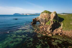 Drone view of an elephant-like natural stone arch on the seashore photo