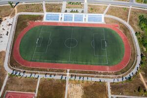 Drone view of an empty soccer field with stands and treadmills photo