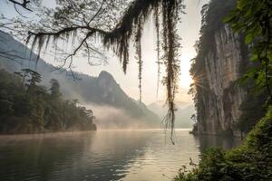 the sun rises over the mountains photo