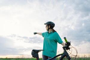 Young Cyclist Looking Up at Cloudy Sky on Sunny Day photo