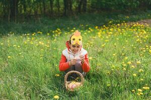 Girl with eggs basket and with a chicken mask on Easter egg hunt photo