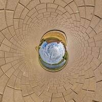 blue sphere inside old town, urban development, historic buildings surrounded by a frame of paving slabs. Transformation of spherical 360 panorama in abstract aerial view. photo