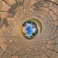 blue sphere overlooking old town, urban development, historic buildings surrounded by a frame of paving slabs. Transformation of spherical 360 panorama in abstract aerial view. photo