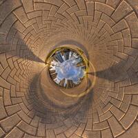 blue sphere inside overlooking urban development, historic buildings surrounded by a frame of paving slabs. Transformation of spherical 360 panorama in abstract aerial view. photo