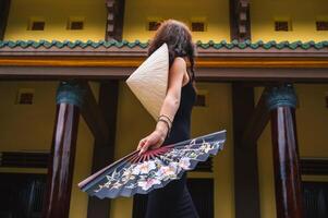 A tourist woman in a traditional Vietnamese Non La hat on the background of beautiful landscapes at the Linh Ung Son Tra pagoda in Da Nang. photo