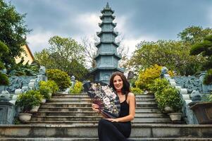 A female tourist on the background of the tower of the Buddhist temple in the Linh Un pagoda in Da Nang in Vietnam in Asia photo