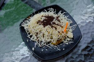 pisang bakar keju. Grilled banana topped with grated cheese and chocolate milk. photo