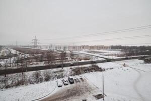 A snowy landscape featuring an overcast sky alongside various infrastructure elements photo
