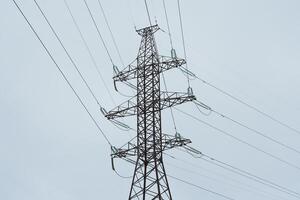 The towering high voltage power lines stand prominent against the expansive sky overhead photo