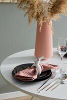 An Elegant Table Setting Featuring a Decorative Bunny and a Modern Vase for Style photo